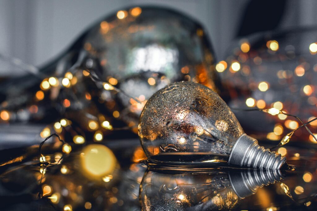 Image of a light bulb laying on a surface with mini lights.