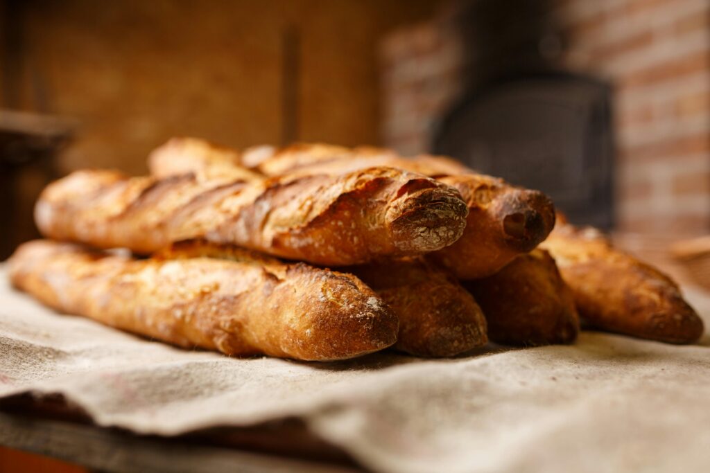 An Image of a stack of freshly-baked bread on a cloth.